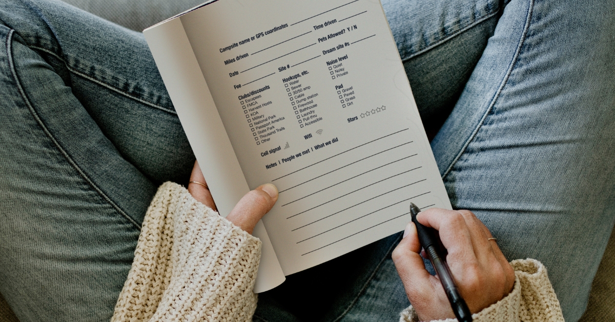 A woman with her legs crossed writing in a journal