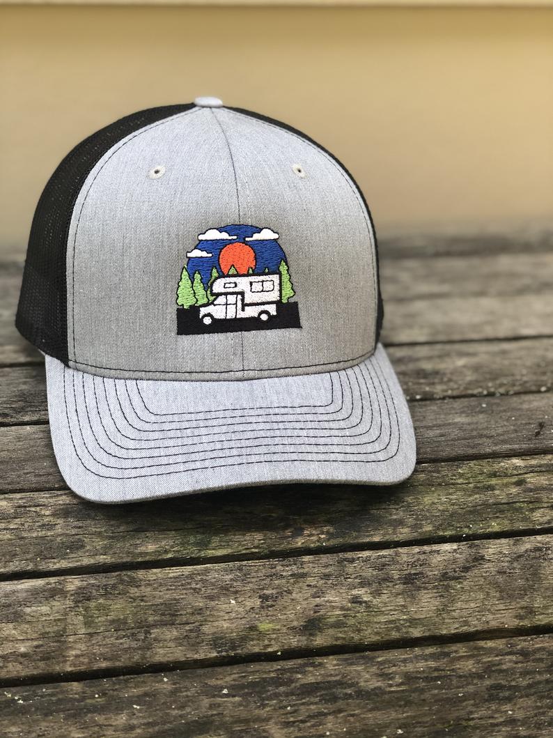 Grey and black hat with an embroidered truck camper graphic
