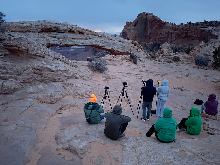 A crowd with cameras at Mesa Arch