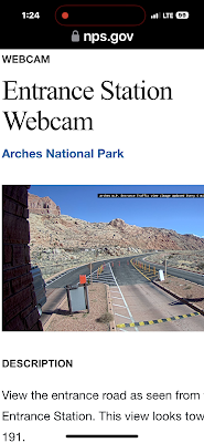 a cell phone screenshot of the Arches National Park entrance station with a van waiting at the gate