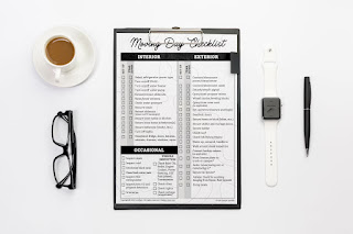 Moving Day checklist on a clipboard with glasses and a coffee mug